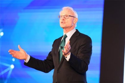 Harvard Business School profesörü Michael E. Porter’ın takım elbiseli, ciddi bakışlarla poz verdiği portresi.